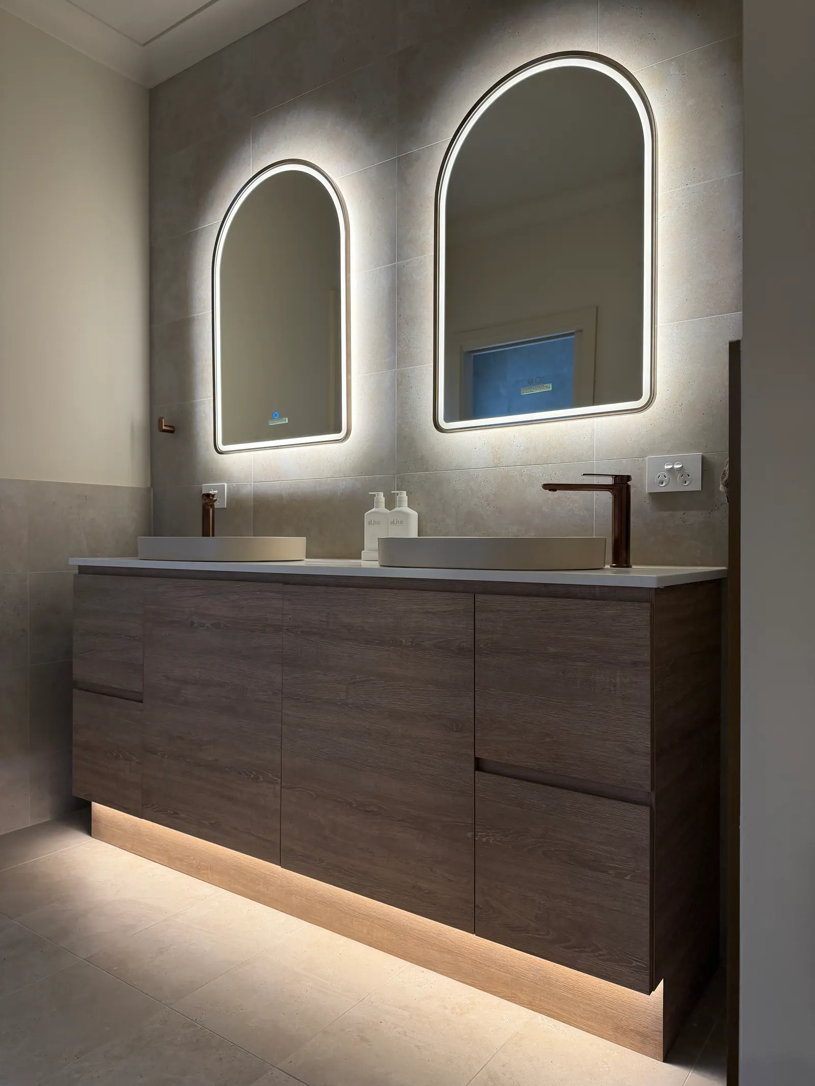 Double vanity with illuminated arched mirrors