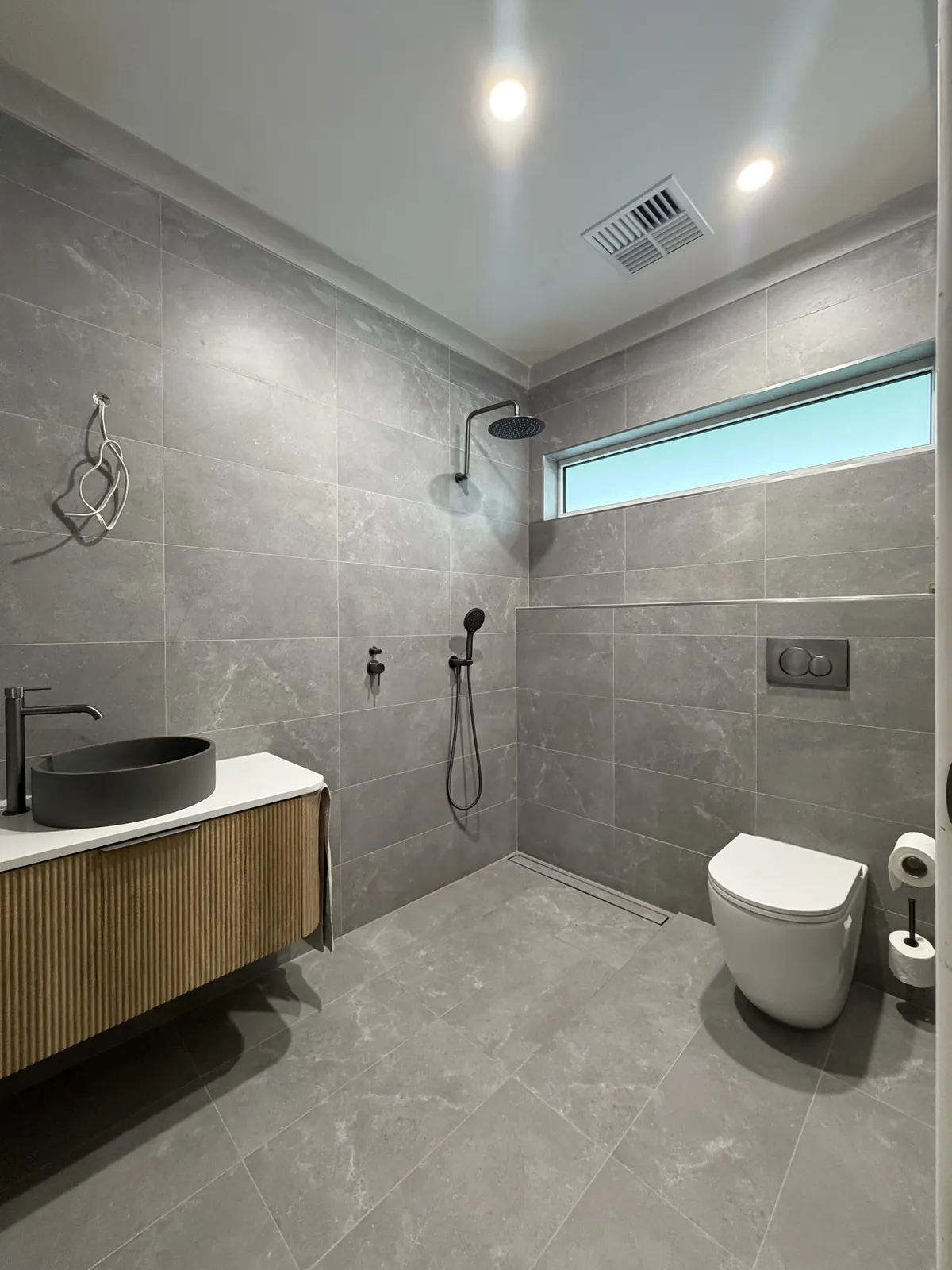 Somerton Park main bathroom after the bath was removed: walk-in shower, wall-hung toilet and timber vanity